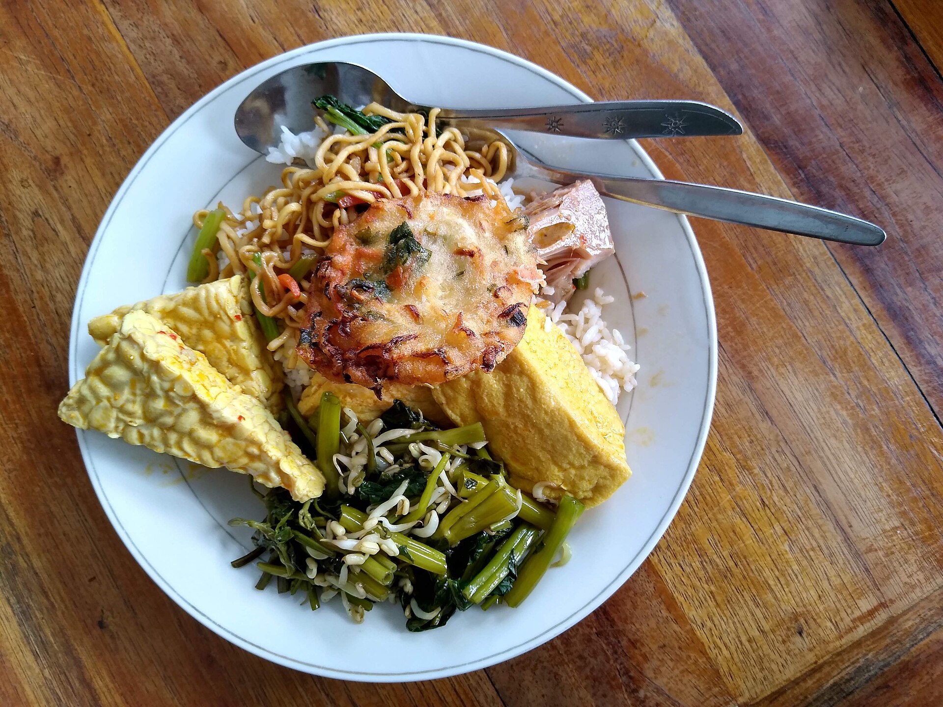 Warung Bu Mi exterior — bamboo, rattan stools, sunlit.